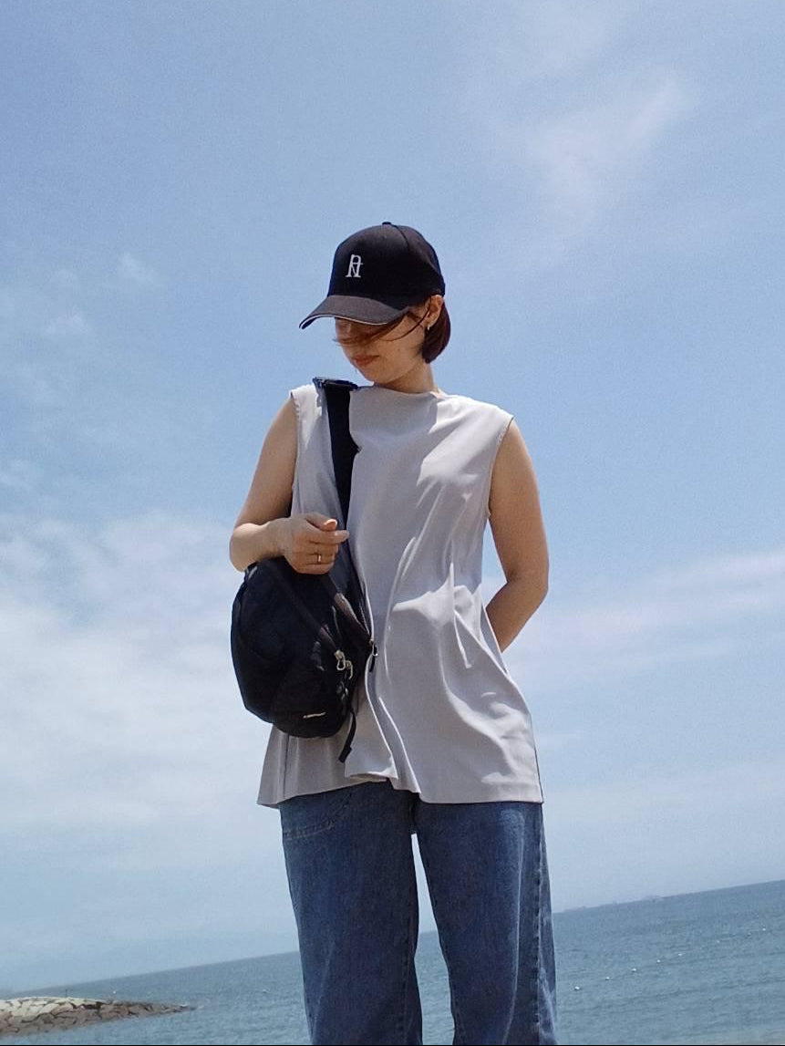 Customer wearing a black FLOUZ crossbody bag by the sea.